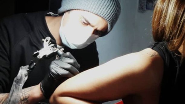 Tattoo artist tattooing a client arm in Black Cadillac Studio